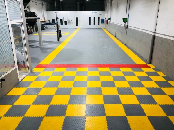 Pardoseală Fortelock Industry montată în șah galben și gri într-un service auto