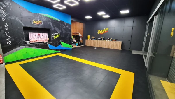 Showroom de detailing auto cu pardoseală Fortelock neagră și contur galben de marcaj