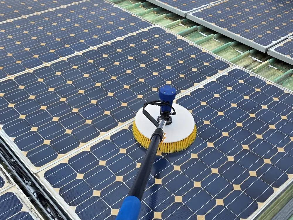 Peria electrică UnicleanSolar, cu disc galben, pe lance, curățând un panou fotovoltaic