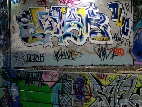 Zid de cărămidă acoperit complet de graffiti colorate