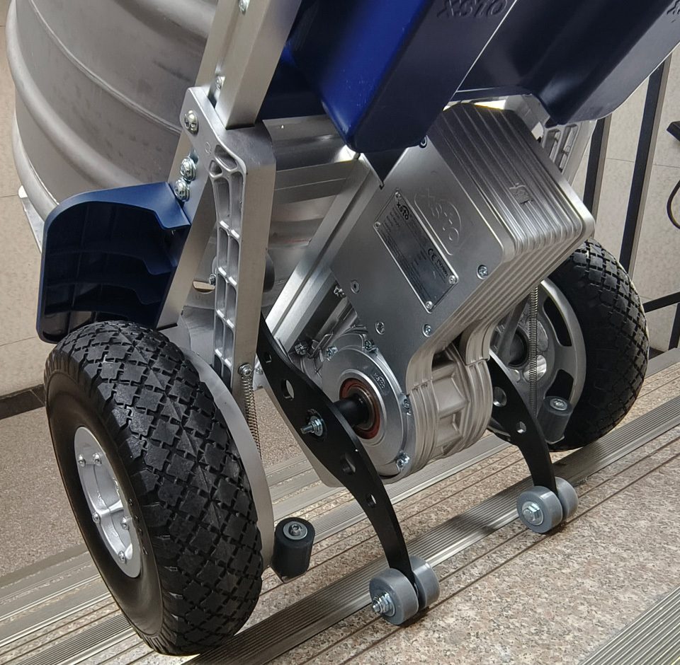 xsto zw7250gc galerie1 Cărucioare electrice pentru scări XSTO - Magazin Online Unilift Serv Prim-plan cu grupul de roți al unui cărucior electric XSTO în timp ce urcă o treaptă